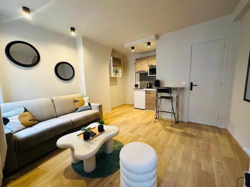 un salon avec un canapé et une table dans l'établissement L'Eiffel - Charmant studio proche Tour Eiffel, à Paris