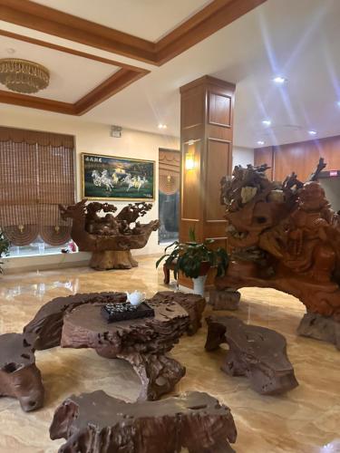 a lobby with a room filled with logs and tables at Khách sạn Vĩnh Lộc in Lao Cai