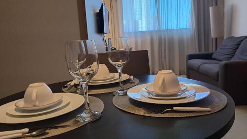 a table with glasses and plates and hats on it at Beach Class Convention - Flats em Boa Viagem por Yolo in Recife