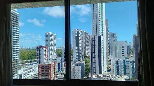 a view of a city skyline from a window at Beach Class Convention - Flats em Boa Viagem por Yolo in Recife