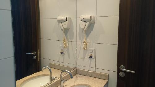 a bathroom with a sink and two phones on the wall at Beach Class Convention - Flats em Boa Viagem por Yolo in Recife