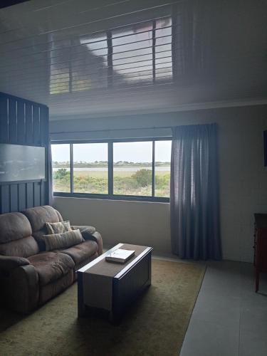 a living room with a couch and a coffee table at Two Lakes in Bettyʼs Bay