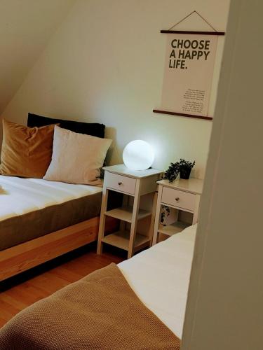 a bedroom with two beds and a table with a lamp at Dat Höhnerstübche in Siegen