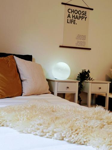 a bed with a white blanket on top of it at Dat Höhnerstübche in Siegen