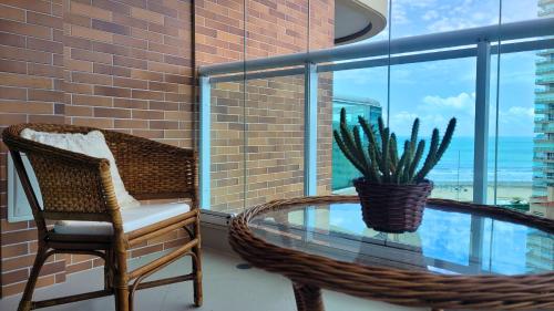 a room with a glass table and a chair and a cactus at BookSantos Estanconfor 1601 Vista Incrível do apê in Santos