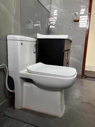 a bathroom with a white toilet in a room at Yb home2 in Rāthdhana