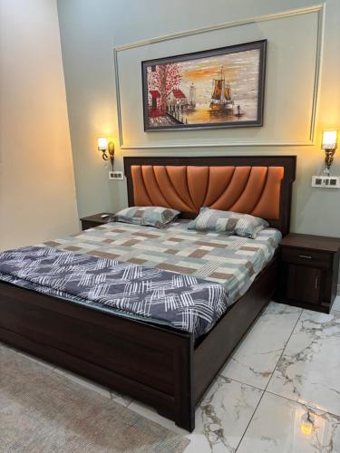 a bedroom with a bed and a painting on the wall at Yb home2 in Rāthdhana