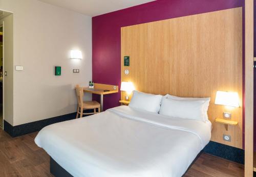 カリュイール・エ・キュイールにあるB&B HOTEL Lyon Caluire Cité Internationaleのベッドルーム(大きな白いベッド1台、テーブル付)