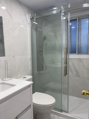 a bathroom with a toilet and a glass shower at 3 bedroom central location montreal close to airport in Laval