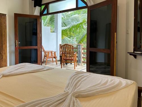 Un dormitorio con una cama y vista a un patio. en Siyon Yula - Guest House, en Hikkaduwa