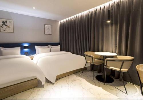 a hotel room with two beds and a table at Day & Night Hotel in Incheon