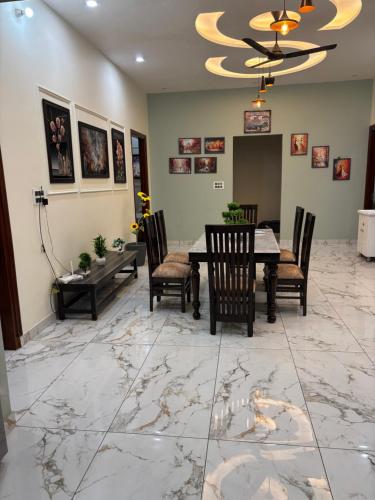 a dining room with a table and chairs on a marble floor at Yb home2 in Rāthdhana