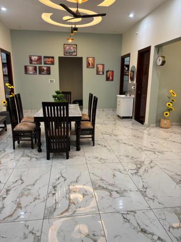a dining room with a table and chairs on a marble floor at Yb home2 in Rāthdhana