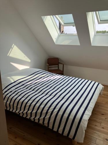 - une chambre mansardée avec un lit rayé dans l'établissement Chez David à Paimpol, à Paimpol