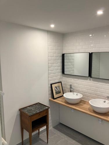 - une salle de bains avec deux lavabos sur un comptoir en bois dans l'établissement Chez David à Paimpol, à Paimpol