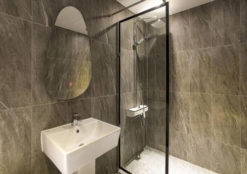 a bathroom with a sink and a glass shower at Day & Night Hotel in Incheon