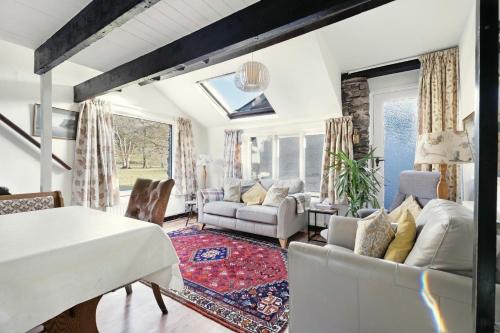 a living room with a white table and chairs at Rowan Studio Cottage in Grasmere