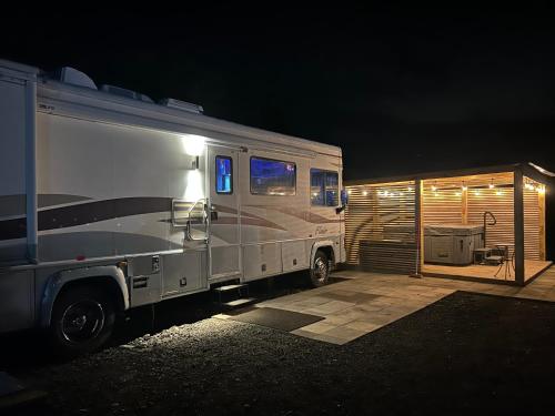 a silver rv parked next to a garage at night at American rv glamping with hot tub in St Asaph