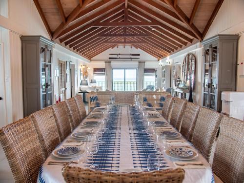 a long dining room with a long table and chairs at The Seahouse Antigua SEAFRONT in Bats Cave