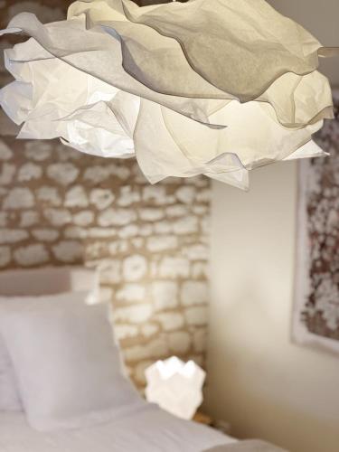 a light hanging from a ceiling in a bedroom at Gîte 1694 - 4 étoiles - proche Futuroscope in Scorbé-Clairvaux