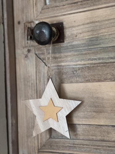 a wooden star hanging on a wooden door at Gîte 1694 - 4 étoiles - proche Futuroscope in Scorbé-Clairvaux