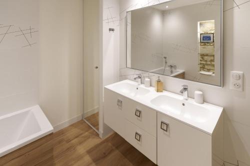 a white bathroom with a sink and a mirror at Gîte 1694 - 4 étoiles - proche Futuroscope in Scorbé-Clairvaux