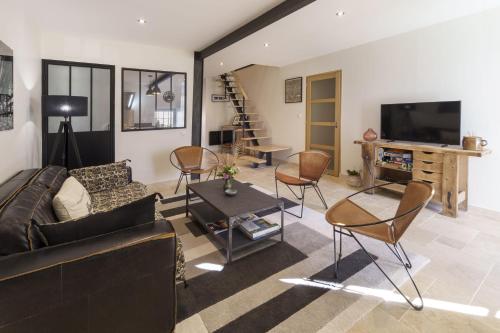 a living room with a couch and chairs and a tv at Gîte 1694 - 4 étoiles - proche Futuroscope in Scorbé-Clairvaux