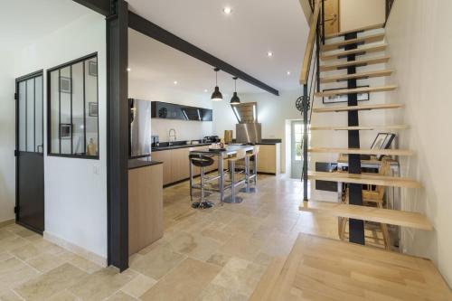 a kitchen and living room with a spiral staircase at Gîte 1694 - 4 étoiles - proche Futuroscope in Scorbé-Clairvaux