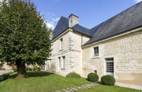a white brick building with a tree in the yard at Gîte 1694 - 4 étoiles - proche Futuroscope in Scorbé-Clairvaux