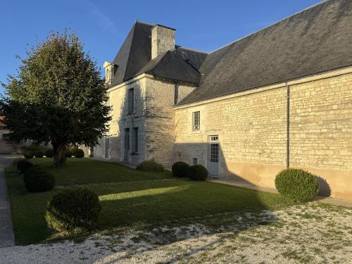 a large brick building with a tree in front of it at Gîte 1694 - 4 étoiles - proche Futuroscope in Scorbé-Clairvaux