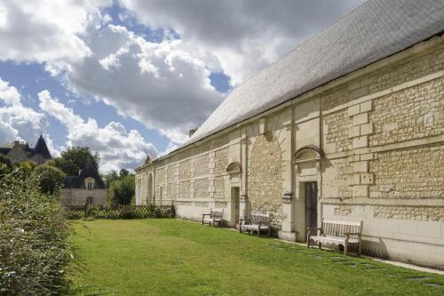 a building with benches on the side of it at Gîte 1694 - 4 étoiles - proche Futuroscope in Scorbé-Clairvaux