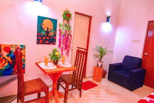a living room with a table and a blue chair at hotel lake freedom in Panadura