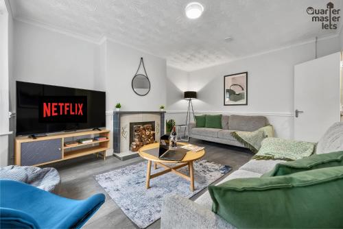 a living room with a couch and a tv at 5 Bedroom Central Townhouse with Parking that Sleeps 9 in Leamington Spa