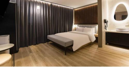 a bedroom with a bed and a bathroom with a sink at Day & Night Hotel in Incheon