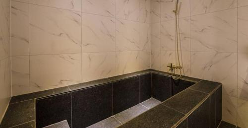 a bathroom with a black and white marble shower at Day & Night Hotel in Incheon