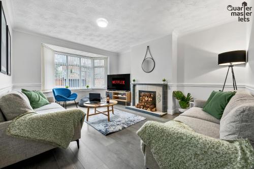 a living room with two couches and a fireplace at 5 Bedroom Central Townhouse with Parking that Sleeps 9 in Leamington Spa
