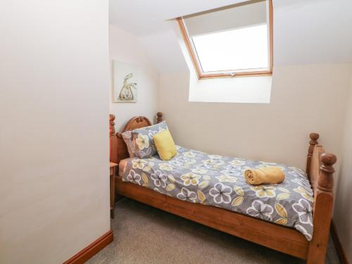 una piccola camera da letto con un letto e una finestra di Old Hall Cottages ad Ashbourne