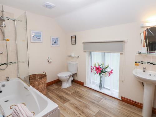 un bagno con vasca, WC e lavandino di Old Hall Cottages ad Ashbourne