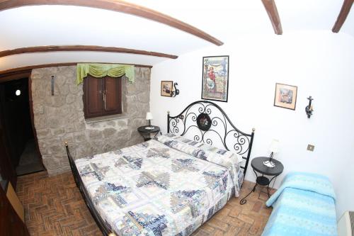 Un dormitorio con una cama y una pared de piedra. en Agriturismo Monte Due Torri, en Genzano di Roma