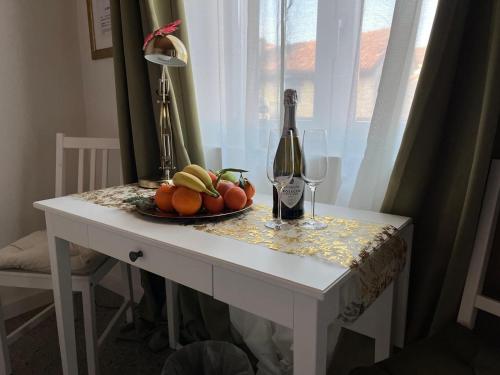 a table with a bottle of wine and a plate of fruit at La casa di Amos in Vaprio dʼAdda