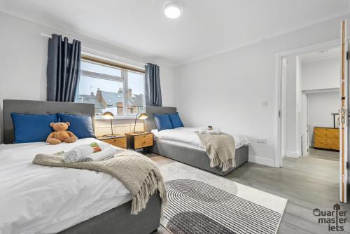 ein Schlafzimmer mit 2 Betten und einem Teddybär auf dem Bett in der Unterkunft 5 Bedroom Central Townhouse with Parking that Sleeps 9 in Leamington Spa