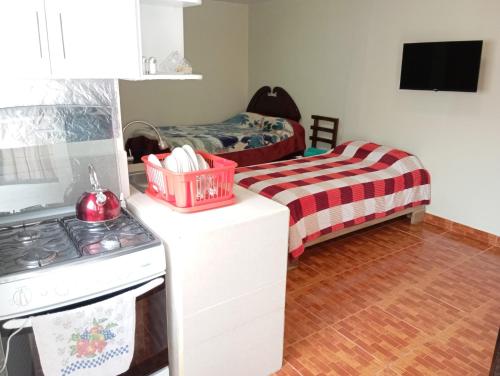 a kitchen with a stove and a bed at Gardenias Suites Full in Ibarra