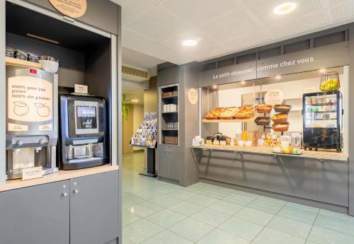 a bakery with a display case in a store at B&B HOTEL Douai Parc Des Expos Cuincy in Cuincy