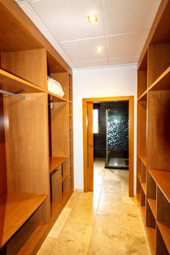 a hallway with wooden shelves and a door into a room at La villa de Naomi in Chella