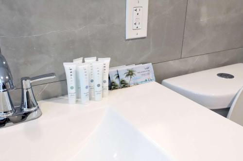 a bathroom with a white sink and a toilet at Ocean Drive Rooftop Suite with Ocean Views & Terrace in Miami Beach