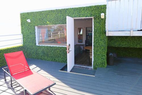 a red chair sitting on a deck next to a building at Ocean Drive Rooftop Suite with Ocean Views & Terrace in Miami Beach