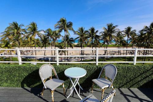 a patio with a table and chairs and palm trees at Ocean Drive Rooftop Suite with Ocean Views & Terrace in Miami Beach