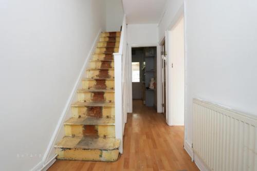 a staircase in a room with a wooden floor at Ritz place 3 in Northolt