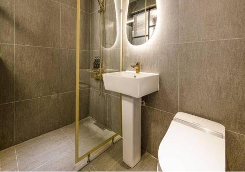 a bathroom with a sink and a toilet and a mirror at Day & Night Hotel in Incheon