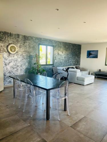 une salle à manger avec une table et des chaises noires dans l'établissement La Maison Laurier, à Lézignan-Corbières